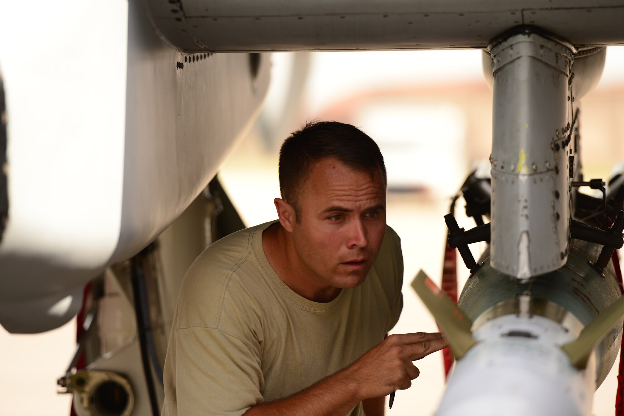 U.S. Air Force Staff Sgt. David Hearing, 25th Aircraft Maintenance Unit weapons loader, checks over the loaded munitions during the quarterly weapons loading competition at Osan Air Base, Republic of Korea, July 10, 2015.  The event adds an element of competition to a qualification test for the technicians; competitors must complete a written test and a practical demonstration of skill within a fixed amount of time in order to maintain mission readiness status. (U.S. Air Force photo by Staff Sgt. Amber Grimm/Released)