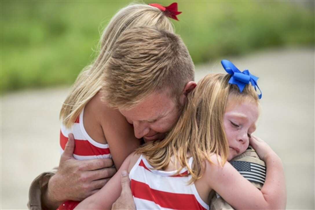 U.S. Air Force Capt. Ross Farling hugs his daughters during a homecoming ceremony at the Kentucky Air National Guard Base in Louisville, Ky., July 4, 2015. Farling was among 39 guardsmen who returned from a deployment to the Persian Gulf region, where they supported Operation Freedom's Sentinel. Farling is a C-130 Hercules pilot assigned to the 123rd Airlift Wing.