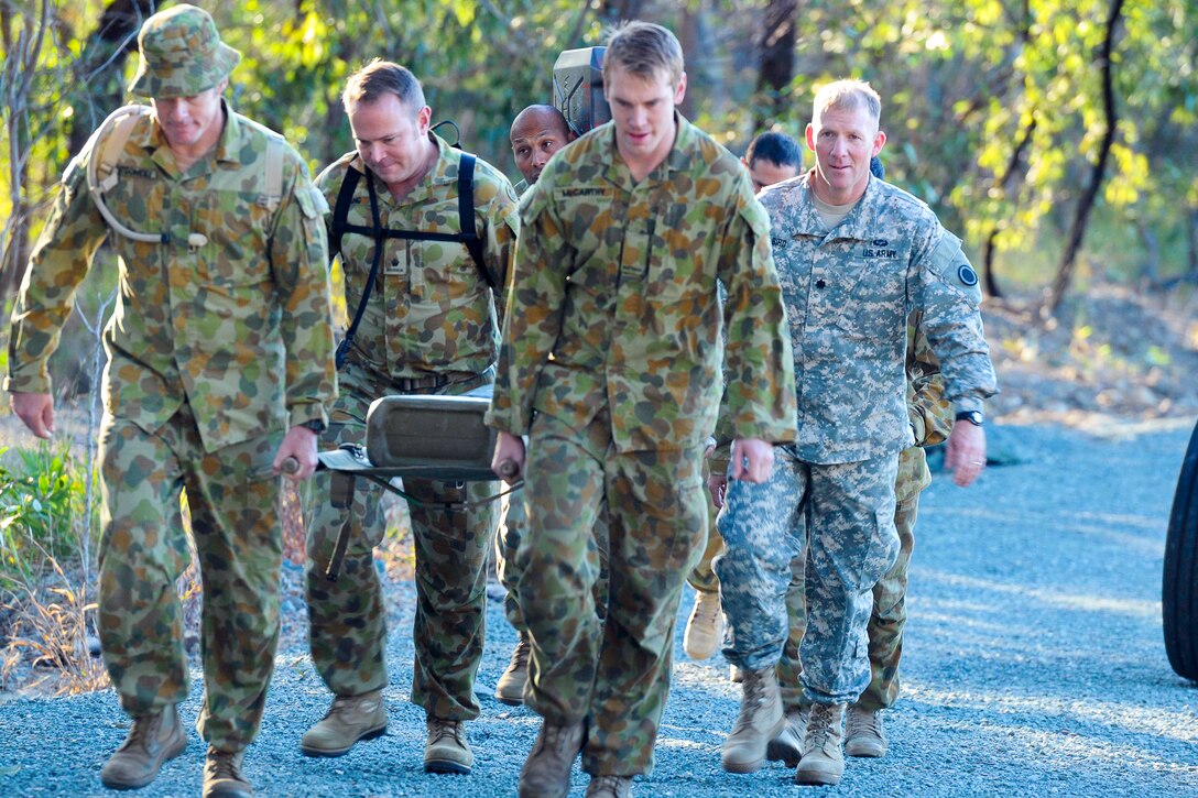 U.S. Army Lt. Col. Ben Bird, right, carries a litter with two 5-liter water cans and two ammunition canisters during a hill walk with Australian soldiers on Gallipoli Barracks, Australia, July 8, 2015, prior to the start of Talisman Sabre 2015. Bird is assigned to I Corps Headquarters Battalion.