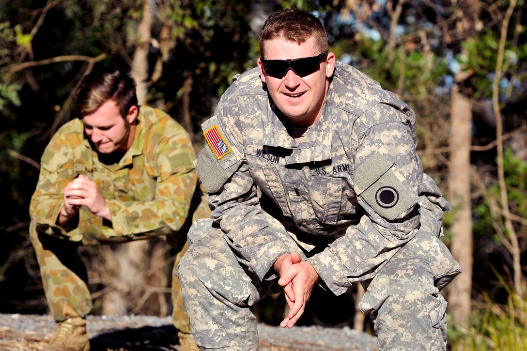 U.S. Army 1st Lt. Joshua Wilson, right, conducts the "Sally" workout after reaching the peak during a hill walk with Australian soldiers on Gallipoli Barracks, Australia, July 8, 2015, prior to the start of Talisman Sabre 15. Wilson is an intelligence officer assigned to I Corps Company A, Headquarters Battalion.