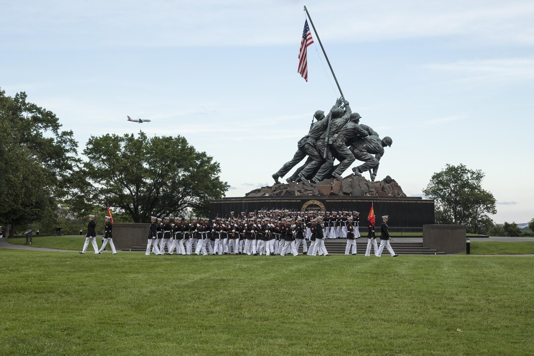 U.S. Marines with the Silent Drill Platoon perform during a sunset parade at the Marine Corps War Memorial, Arlington, Va., July 14, 2015. Dr. Jamie M. Morin, Director, Cost Assessment and Program Evaluation, was the guest of honor for the parade, and Lt. Gen. Robert E. Schmidle, principal deputy director Assessment and Program Evaluation, was the hosting official. Since September 1956, marching and musical units from Marine Barracks Washington, D.C., have been paying tribute to those who’s “uncommon valor was a common virtue” by presenting sunset parades in the shadow of the 32-foot high figures of the United States Marine Corps War Memorial. (U.S. Marine Corps photo by Lance Cpl. Samantha K. Draughon/ Released)
