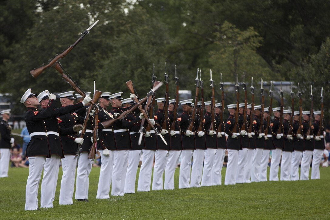 U.S. Marines with the Silent Drill Platoon perform during a sunset parade at the Marine Corps War Memorial, Arlington, Va., July 14, 2015. Dr. Jamie M. Morin, Director, Cost Assessment and Program Evaluation, was the guest of honor for the parade, and Lt. Gen. Robert E. Schmidle, principal deputy director Assessment and Program Evaluation, was the hosting official. Since September 1956, marching and musical units from Marine Barracks Washington, D.C., have been paying tribute to those whose “uncommon valor was a common virtue” by presenting sunset parades in the shadow of the 32-foot high figures of the United States Marine Corps War Memorial. (U.S. Marine Corps photo by Lance Cpl. Hailey D. Stuart/Released)