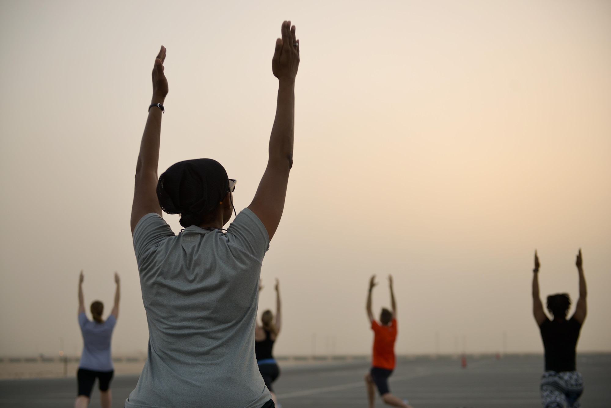 Deployed Soldiers, sailors, airmen, marines, coalition partners and civilians go into the Warrior One pose during the largest Yoga session to take place in Qatar history July 11, 2015 Al Udeid Air Base, Qatar. This event opened its doors to all levels of practitioners from novice to expert. It allowed the fine men and women assigned to Al Udeid Air Base to relax and enjoy a different kind of exercise in a neutral environment. (U.S. Air Force photo/Staff Sgt. Alexandre Montes)