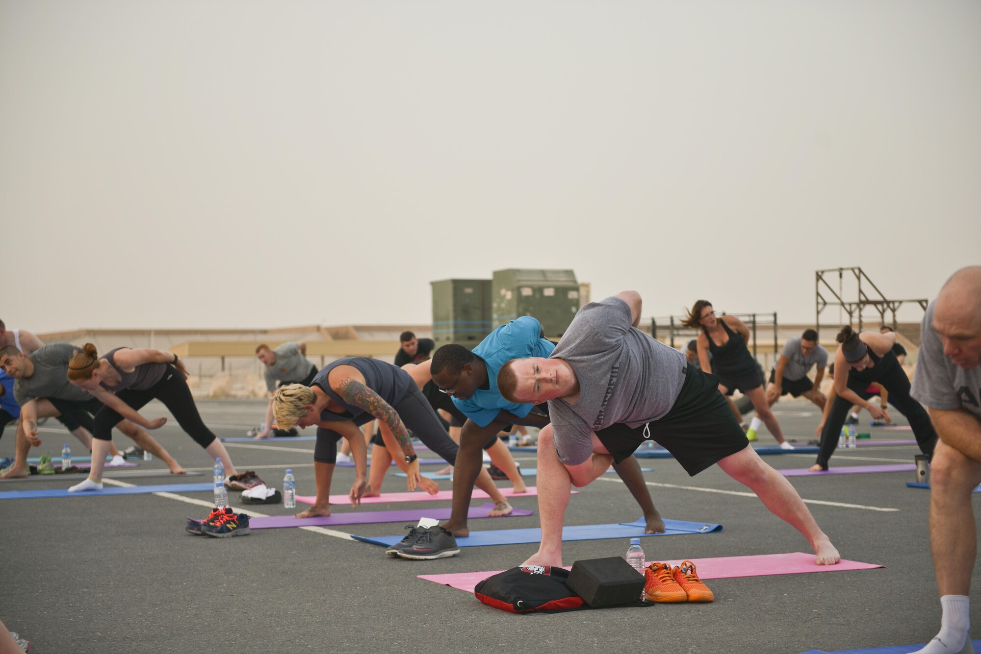 Deployed Soldiers, sailors, airmen, marines, coalition partners and civilians go into the Vine pose during the largest Yoga session to take place in Qatar history July 11, 2015 Al Udeid Air Base, Qatar. This event opened its doors to all levels of practitioners from novice to expert. It allowed the fine men and women assigned to Al Udeid Air Base to relax and enjoy a different kind of exercise in a neutral environment. (U.S. Air Force photo/Staff Sgt. Alexandre Montes)