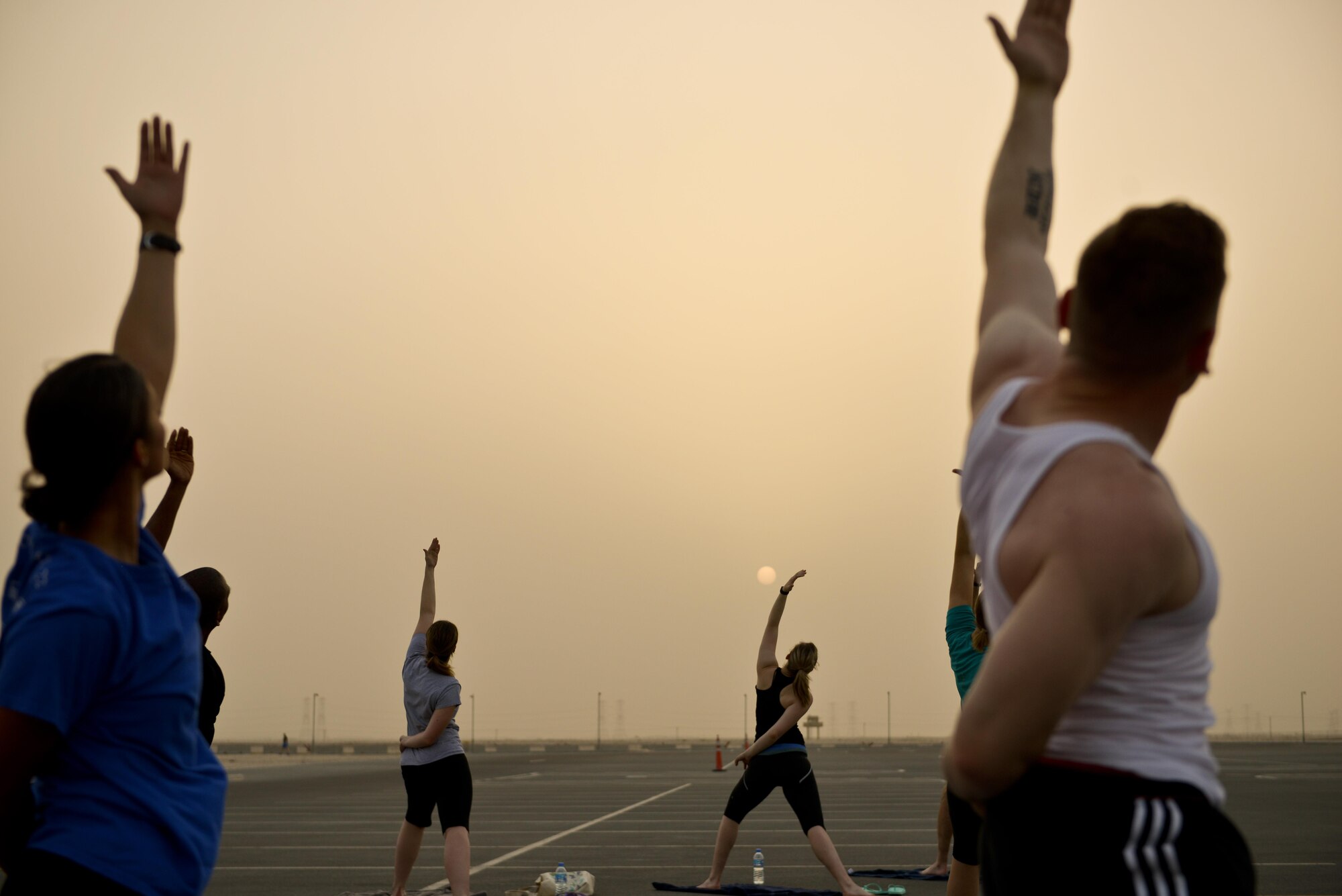 Deployed Soldiers, sailors, airmen, marines, coalition partners and civilians go into the Reverse Warrior pose during the largest Yoga session to take place in Qatar history July 11, 2015 Al Udeid Air Base, Qatar. This event opened its doors to all levels of practitioners from novice to expert. It allowed the fine men and women assigned to Al Udeid Air Base to relax and enjoy a different kind of exercise in a neutral environment. (U.S. Air Force photo/Staff Sgt. Alexandre Montes)