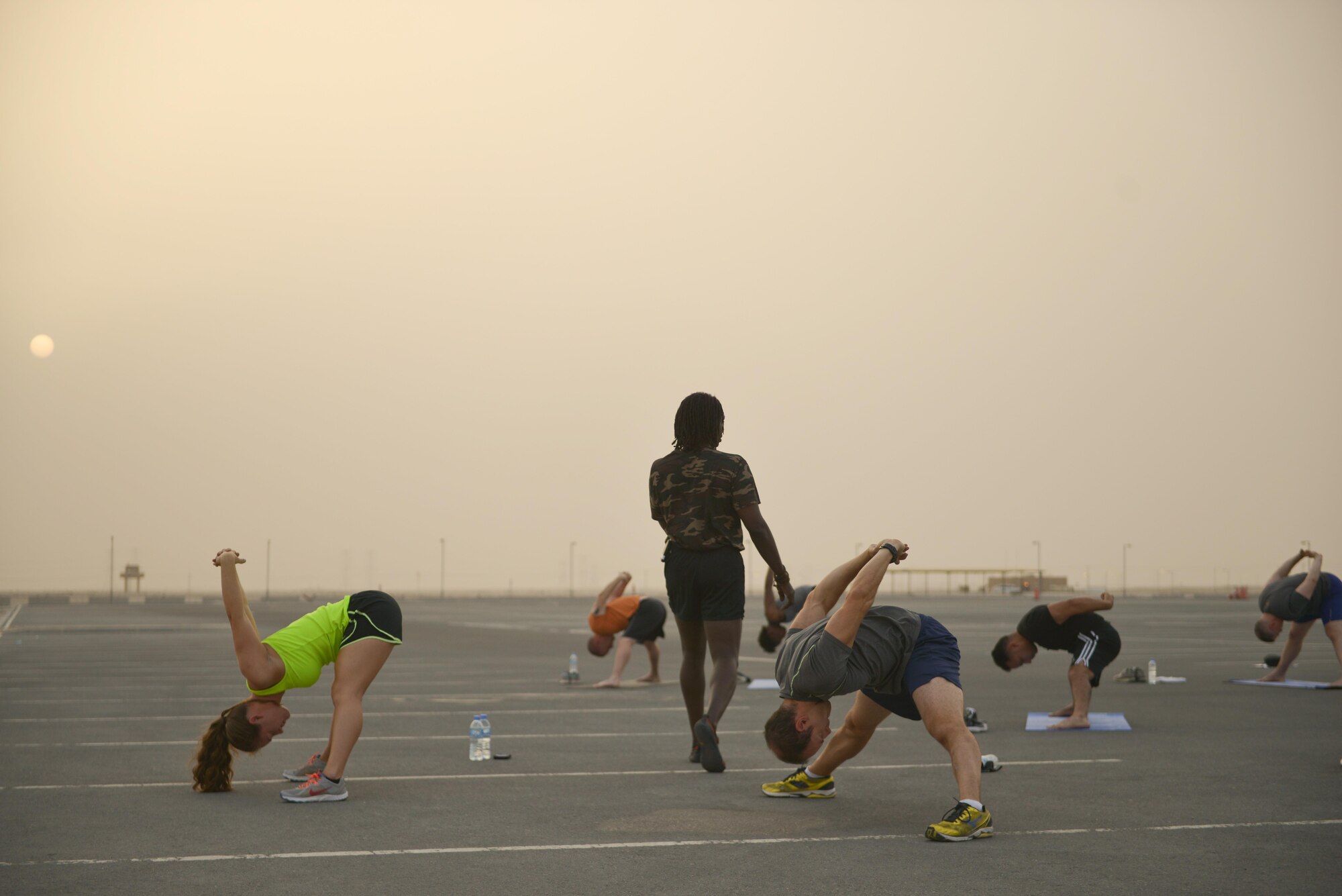 Tracy English, 609th Air and Space Operations Center historian, leads deployed members into a cool down stretch to help end the largest Yoga session to take place in Qatar history July 11, 2015 Al Udeid Air Base, Qatar. Tracy English and a few of the other yogis deployed to Al Udeid put together a power yoga routine and introduced it to the base during the largest yoga session in Qatar to date.  (U.S. Air Force photo/Staff Sgt. Alexandre Montes)