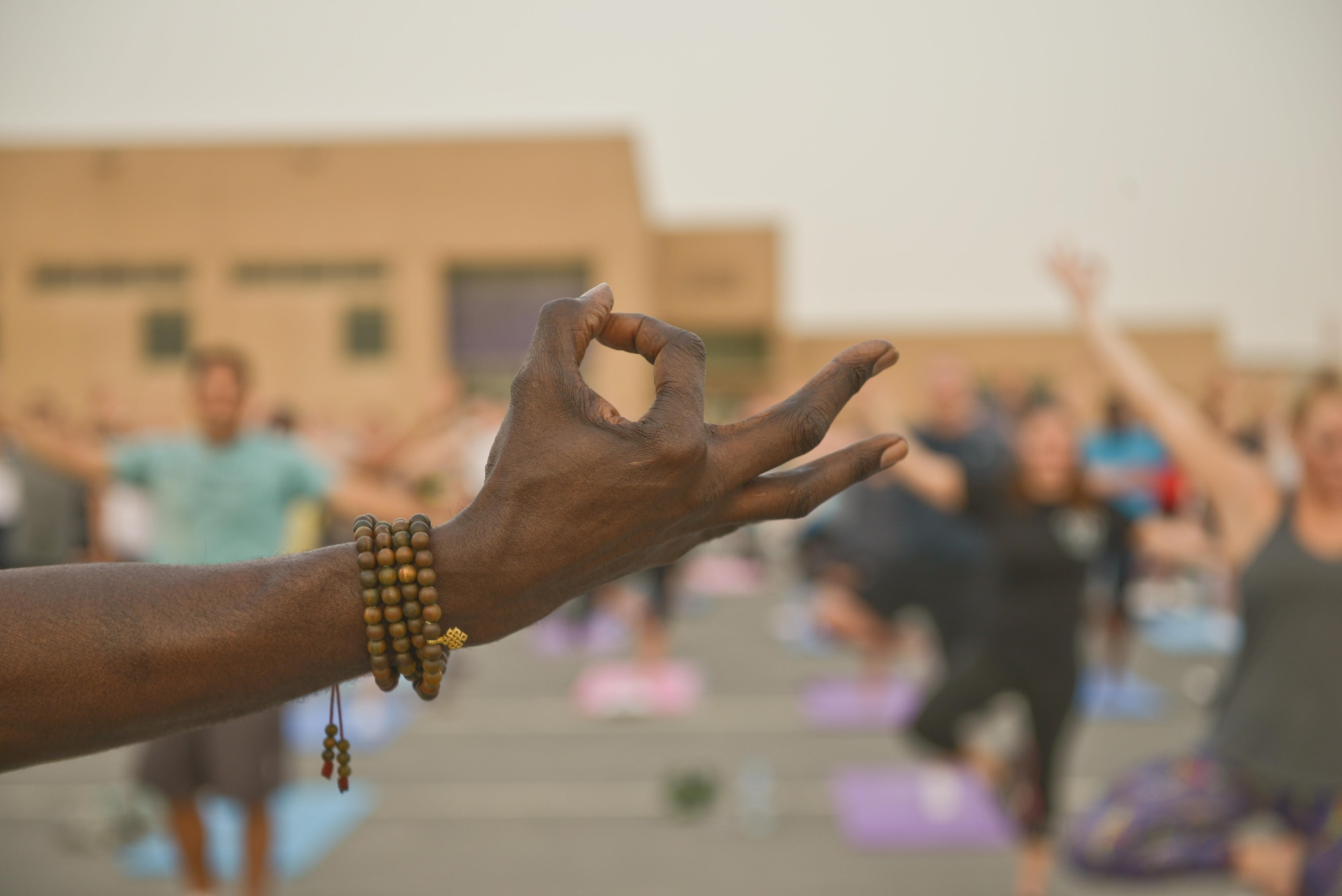 Tracy English, 609th Air and Space Operations Center historian, instructs deployed personnel on how to begin a Tree pose during the largest Yoga session to take place in Qatar history July 11, 2015 Al Udeid Air Base, Qatar. Tracy English and a few of the other yogis deployed to Al Udeid put together a power yoga routine and introduced it to the base during the largest yoga session in Qatar to date.  (U.S. Air Force photo/Staff Sgt. Alexandre Montes)