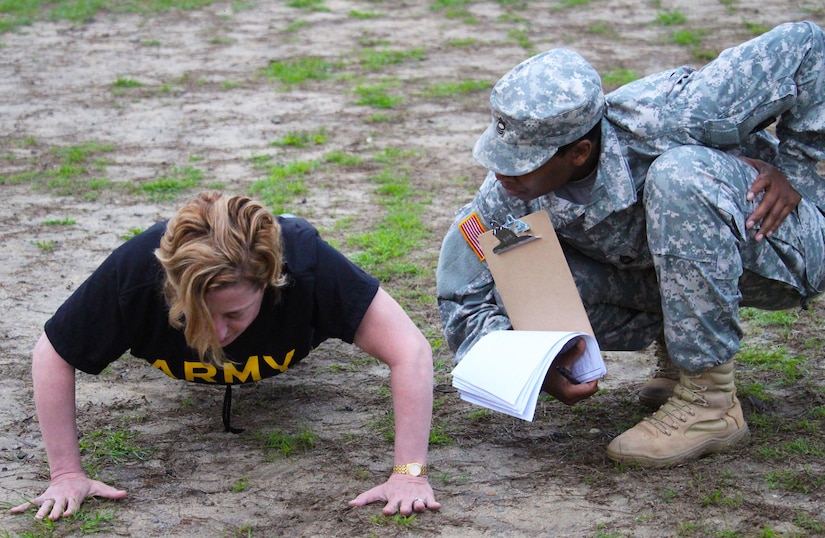 Master Sgt. Tomeka Brown, of the 81st Regional Support Command, grades Brig. Gen. Mary Kate Leahy during the pushup event of the Army physical fitness test.