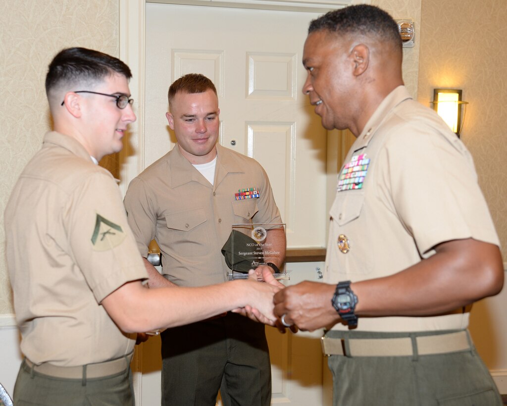 Maj. Gen. Craig Crenshaw, commanding general, Marine Corps Logistics Command, (right) congratulates Lance Cpl. Ethan Kortie, administrative specialist, (left) who received the award for Marine of the Year, and Sgt. Steven McGahee, postal noncommissioned officer, Adjutant’s Office, MCLB Albany, who received recognition as Noncommissioned Officer of the Year. The Marines were recognized during the annual Military Appreciation Rise and Shine Breakfast at the Hilton Garden Inn in downtown Albany, Georgia, July 15.  