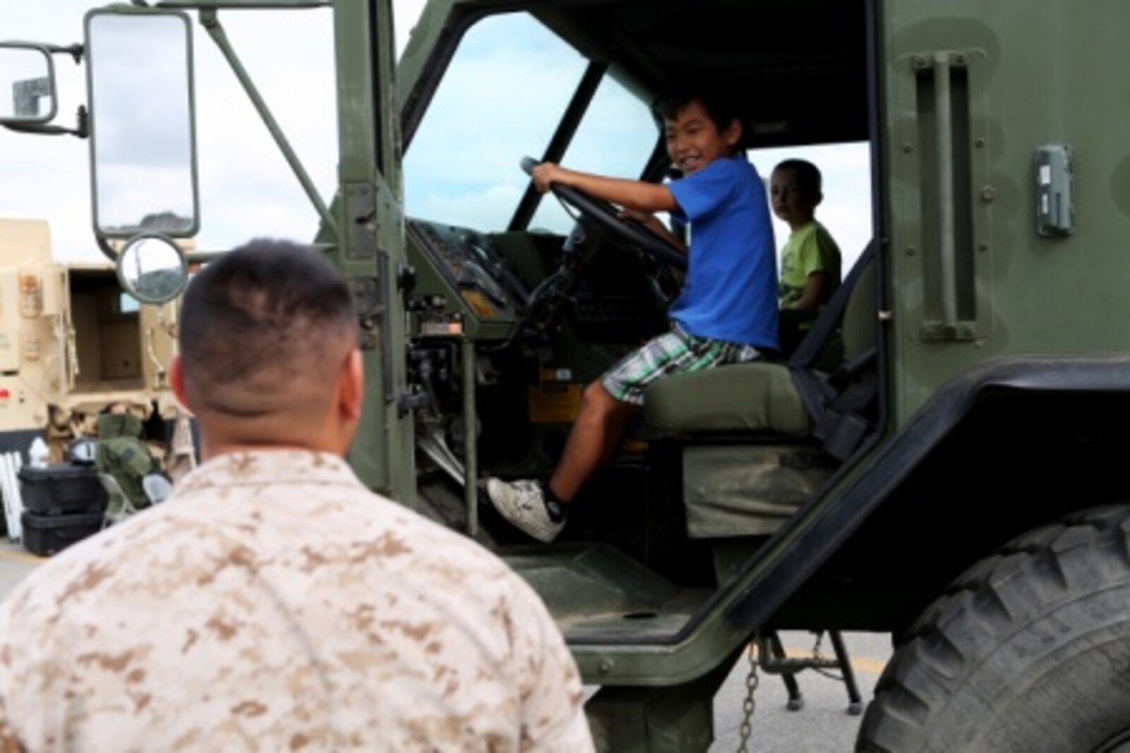 Sergeant Michael Obado, heavy equipment floor chief, 7th Engineer Support Battalion, 1st Marine Logistics Group, watches as his little boy, Nozo, explores an armored truck at a family day celebration for Marines and Sailors of 7th ESB aboard Camp Pendleton, Calif., July 10, 2015. Included in the celebration were bouncy houses and displays that allowed them to look at things like sniper rifles, armored vehicles and Explosive Ordnance Disposal gear.
