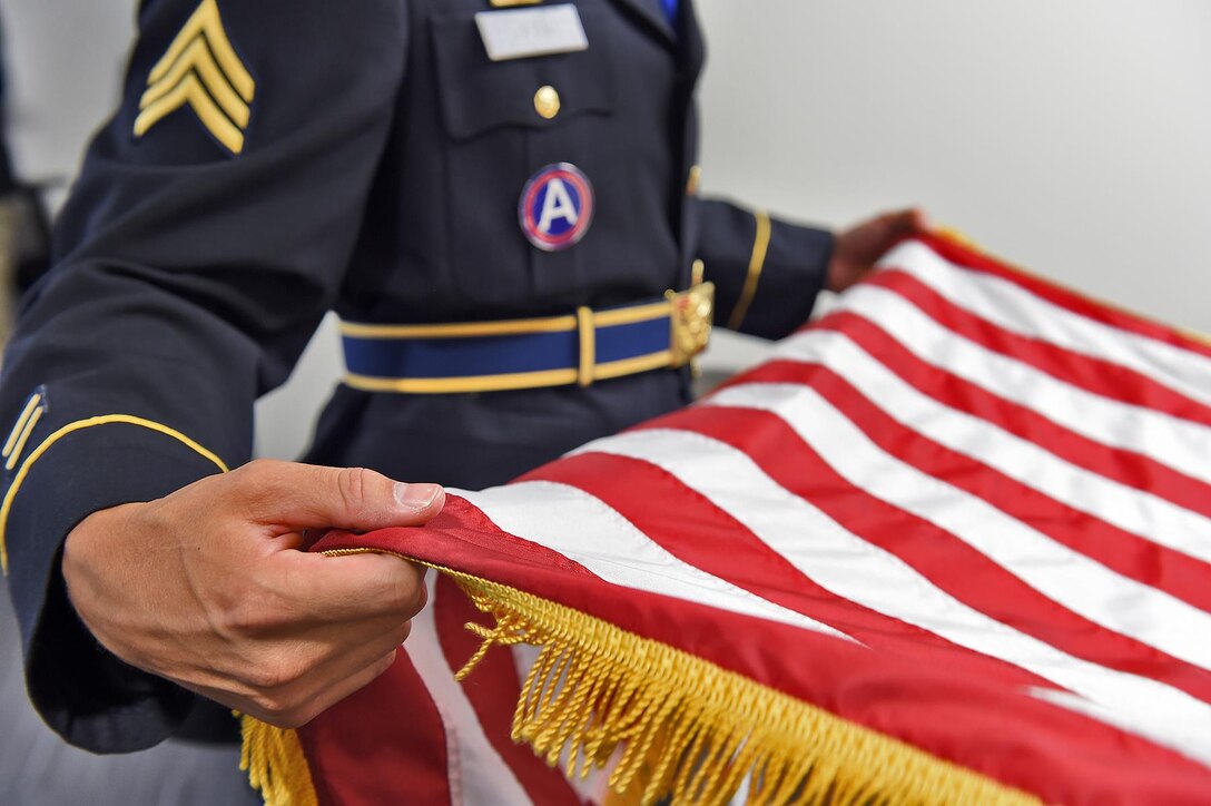 An Army Reserve soldier, assigned to the Chicago based 85th Support Command, unfurls a U.S. flag prior to a presentation of colors during the Chicago Cubs vs. Miami Marlins game at Wrigley Field with more than 41,000 in attendance, July 3. The game was one of three games that members from the 85th Support Command took part in during the Fourth of July weekend. (U.S. Army photo by Sgt. 1st Class Anthony L. Taylor/Released)