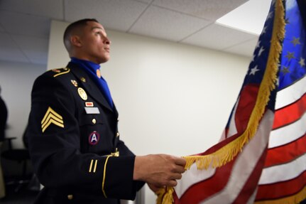 Sgt. Angel Olivo, assigned to the Chicago based 85th Support Command, prepares a U.S. flag before a presentation of colors at the Chicago Cubs vs Miami Marlins game at Wrigley Field with more than 41,000 in attendance, July 3. The game was one of three games, during the Fourth of July weekend, for soldiers participating from the local unit. (U.S. Army photo by Sgt. 1st Class Anthony L. Taylor/Released)