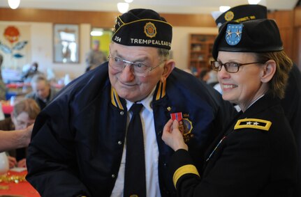 World War II veteran Clifford P. Blaha stands beside Maj. Gen. Karen LeDoux, commander of the 88th Regional Support Command, after being presented the Bronze Star Medal during a ceremony in Ettrick, Wis., March 21. Blaha is a veteran of operations in Leyte, Philippines and the Battle of Okinawa. He is a recipient of two Purple Hearts, the  American Campaign Medal, the Asiatic Pacific Medal, the World War II Victory Medal and the Combat Infantry Badge. “Mr. Blaha’s service to our nation holds just as much importance today as it did 70 years ago when he bore the hardships of war,” said LeDoux. “As his generation passes we must remind ourselves and teach our youth the heroism and sacrifices which were endured for future generations.”