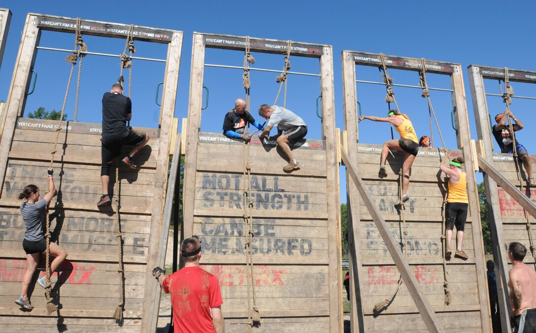 (Center column) Chaplain Sam Thomas, deputy command chaplain of the 103rd Expeditionary Sustainment Command (left), and Capt. Michael Wittkowski, commander of the 646th Regional Support Group, Headquarters, Headquarters Company (right), negotiate an obstacle during the Tough Mudder event held in Plymouth, Wis., Sept. 6. Tough Mudder events are obstacle courses designed to test competitors’ all around strength, stamina, mental grit and camaraderie. “This is all about teamwork, it’s all about a coming together, and hitting the obstacles as a team,” said Thomas. “This is not an individual event, it’s about working together and overcoming the obstacles as a team.”