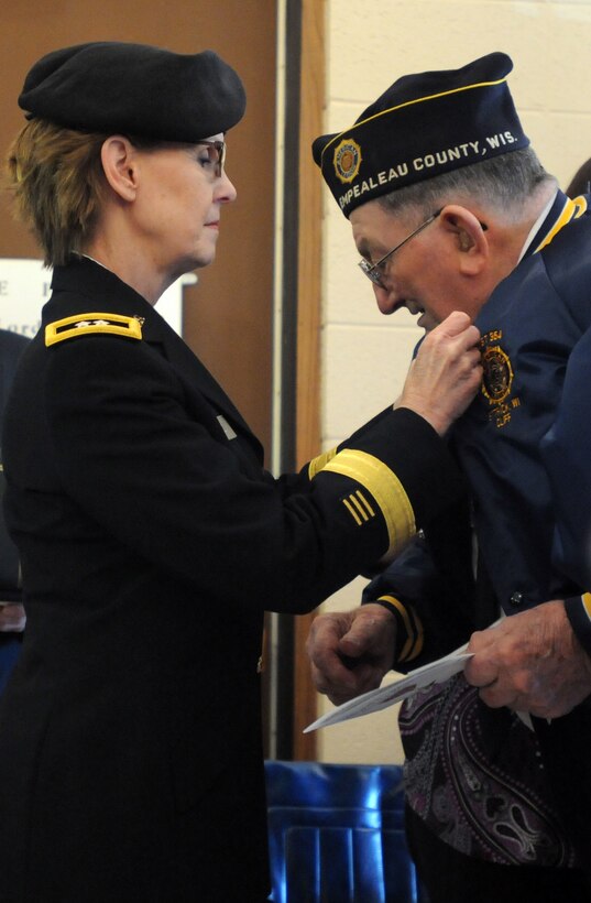 Maj. Gen. Karen LeDoux, commander of the 88th Regional Support Command, presents World War II veteran Clifford P. Blaha the Bronze Star Medal during a ceremony in Ettrick, Wis., March 21. Blaha is a veteran of operations in Leyte, Philippines and the Battle of Okinawa. He is a recipient of two Purple Hearts, the American Campaign Medal, the Asiatic Pacific Medal, the WWll Victory Medal and the Combat Infantry Badge. “Mr. Blaha’s service to our nation holds just as much importance today as it did 70 years ago when he bore the hardships of war,” said LeDoux. “As his generation passes we must remind ourselves and teach our youth the heroism and sacrifices which were endured for future generations.”