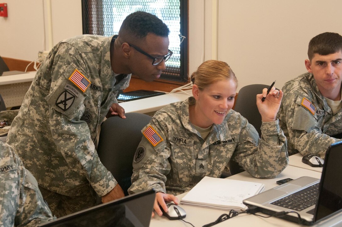Sgt. 1st Class Demario Q. Arnold, the senior paralegal noncommissioned officer with the 153rd Legal Operations Detachment, helps Sgt. Sarah G. Gyhra, a paralegal with the 561st Regional Support Group, during the classroom portion of the 2015 Paralegal Warrior Training Course here July 13. Arnold is a resident of Charlotte and Gyhra is a resident of Pawnee City, Neb. (U.S. Army photo by Sgt. Darryl L. Montgomery, 319th Mobile Public Affairs Detachment)