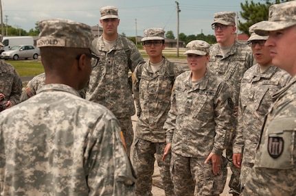 Students huddle around as Sgt. 1st Class Demario Q. Arnold, the senior paralegal noncommissioned officer with the 153rd Legal Operations Detachment, discusses ways students can improve upon their skillset of working in a claims office in a deployed environment during the 2015 Paralegal Warrior Training Course here July 13. Arnold is a resident of Charlotte. (U.S. Army photo by Sgt. Darryl L. Montgomery, 319th Mobile Public Affairs Detachment)