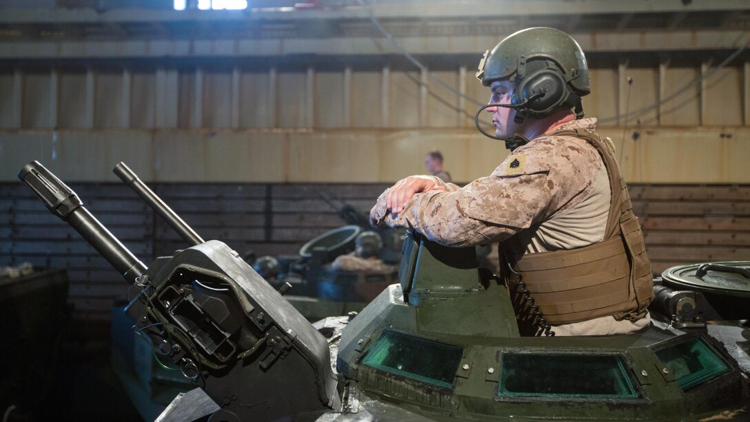 U.S. Marine Sgt. Scott Wheeler waits in the turret of his AAV-P7/A1 Amphibious Assault Vehicle in the well deck of the USS Ashland (LSD 48) before an amphibious assault at Fog Bay, Australia, July 11, 2015. The Marines with Company E, Battalion Landing Team 2nd Battalion, 5th Marines, 31st Marine Expeditionary Unit, and Australians with Combat Team Bravo, 2nd Battalion, Royal Australian Regiment, assaulted the beach and moved inland to secure additional objectives as part of Talisman Sabre 2015. Talisman Sabre is a biennial exercise designed to improve the interoperability between Australian and U.S. forces. The 31st MEU is taking part in the exercise while deployed on its regularly scheduled Fall Patrol of the Asia-Pacific region. Wheeler, a native of Mansfield, Pennsylvania, is an AAV section leader with Co. E, BLT 2/5, 31st MEU. 