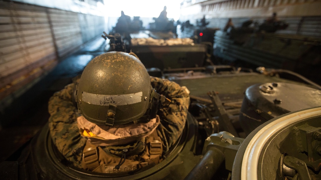 U.S. Marine Lance Cpl. David Belgard waits in an AAV-P7/A1 Amphibious Assault Vehicle in the well deck of the USS Ashland (LSD 48) for an amphibious assault begin at Fog Bay, Australia, July 11, 2015. Talisman Sabre is a biennial exercise designed to improve the interoperability between Australian and U.S. forces. The 31st MEU is taking part in the exercise while deployed on its regularly scheduled Fall Patrol of the Asia-Pacific region. Belgard, a native of Huffman, Texas, is an AAV crew chief with Co. E, BLT 2/5, 31st MEU. 