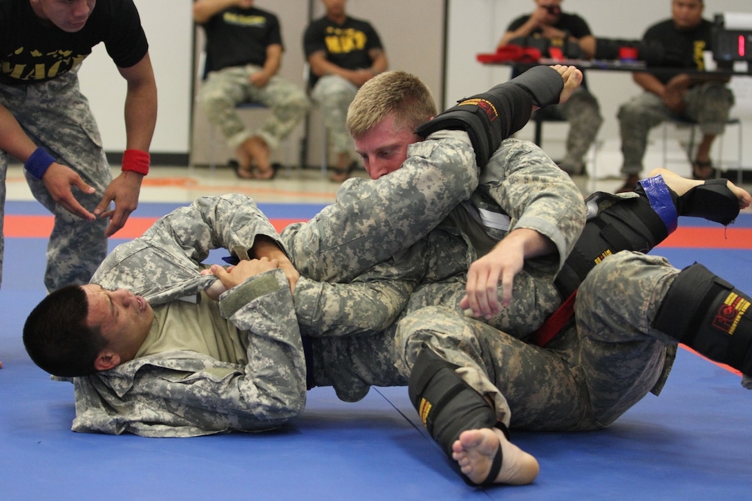 U.S. Army Spc. Justin Trusso, a carpentry and masonry specialist assigned to the 797th Engineer Company, 411th Engineer Battalion, 9th Mission Support Command, tries to lock in an arm bar on Sgt. Jeremiah Bruce, an infantryman assigned to Headquarters and Headquarters Company, 100th Battalion, 442nd Infantry Regiment, 9th MSC, during the combatives event of the Pacific Army Reserve Best Warrior Competition, at Fort Shafter, Hawaii, May 22, 2013.  (Photo by Army Staff Sgt. Joseph Vine, 305th Mobile Public Affairs Detachment)