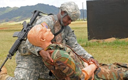 Anchorage-based soldier Sgt. Joseph Clark, pharmacy technician, 1984th U.S. Army Hospital, 9th Mission Support Command, evaluates a simulated casualty here, May 8. Clark was evaluated on his ability to properly assess and provide the appropriate care for injuries found on the battle field as part of the Pacific Army Reserve Best Warrior Competition. (Photo by Sgt. Joseph Vine)