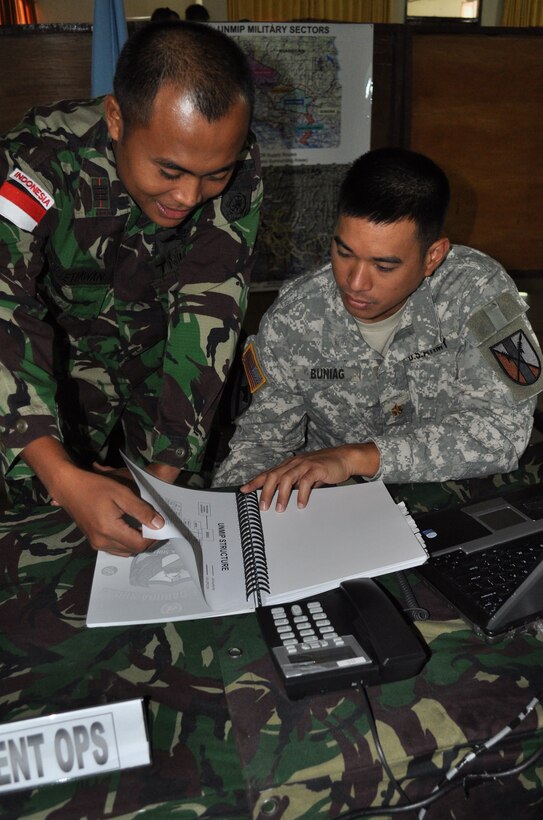 Maj. Alejandro Buniag and Capt. Risa Setyawan, Force Headquarters operations officers for the command post exercise, work hard to solve simulated, complex scenarios, June 16, during Exercise Garuda Shield. Bunian and Setyawan are among the many U.S. and Indonesian soldiers who are working side by side, during the two-week CPX.