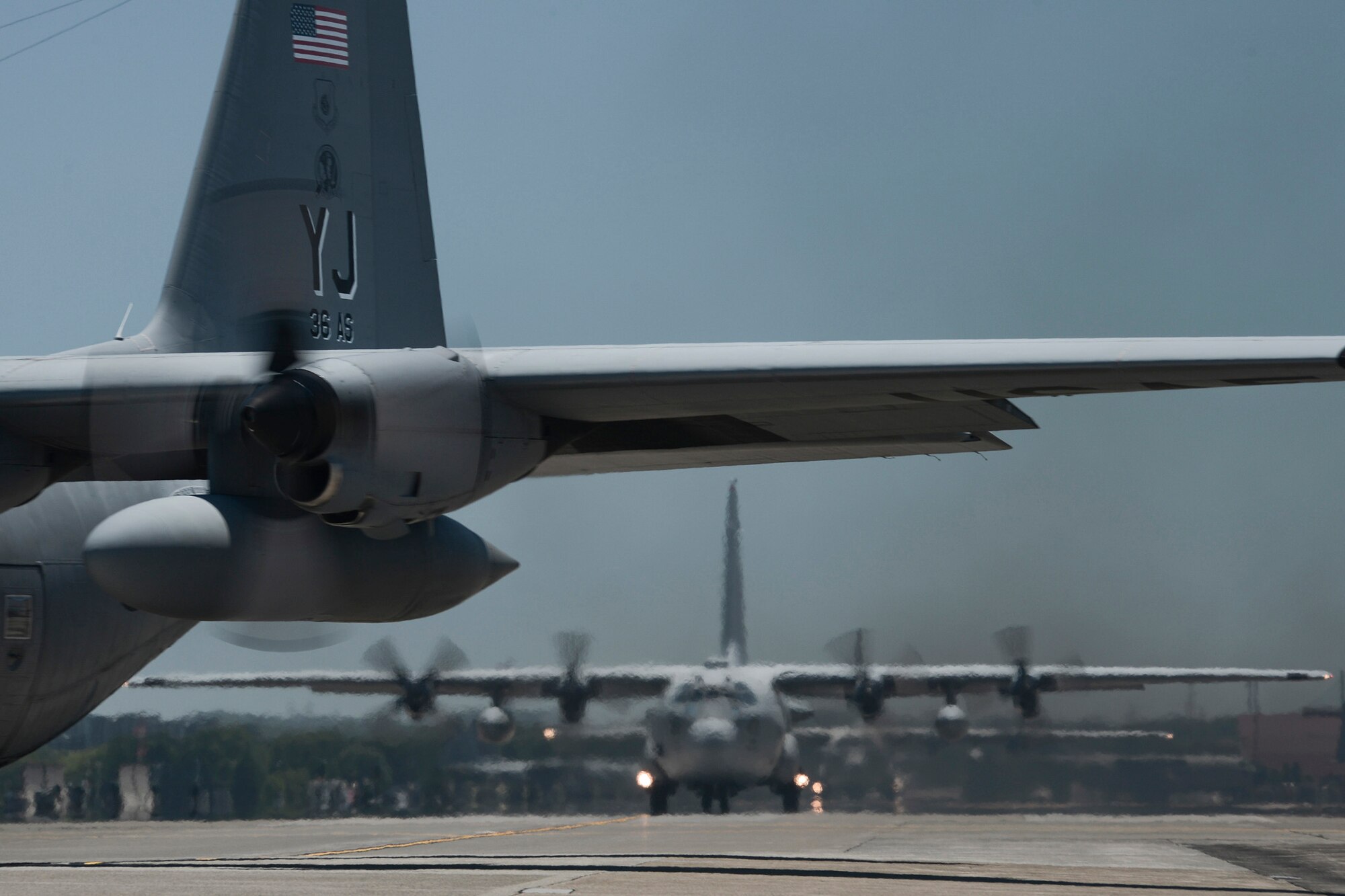 Multiple U.S. Air Force C-130 Hercules taxi during large formation training, Yokota Air Base, Japan, July 14, 2015. Yokota is the primary airlift hub in the Indo-Asia-Pacific region, and the training allowed members to practice mission essential airlift capabilities. (U.S. Air Force photo by Staff Sgt. Cody H. Ramirez/Released) 