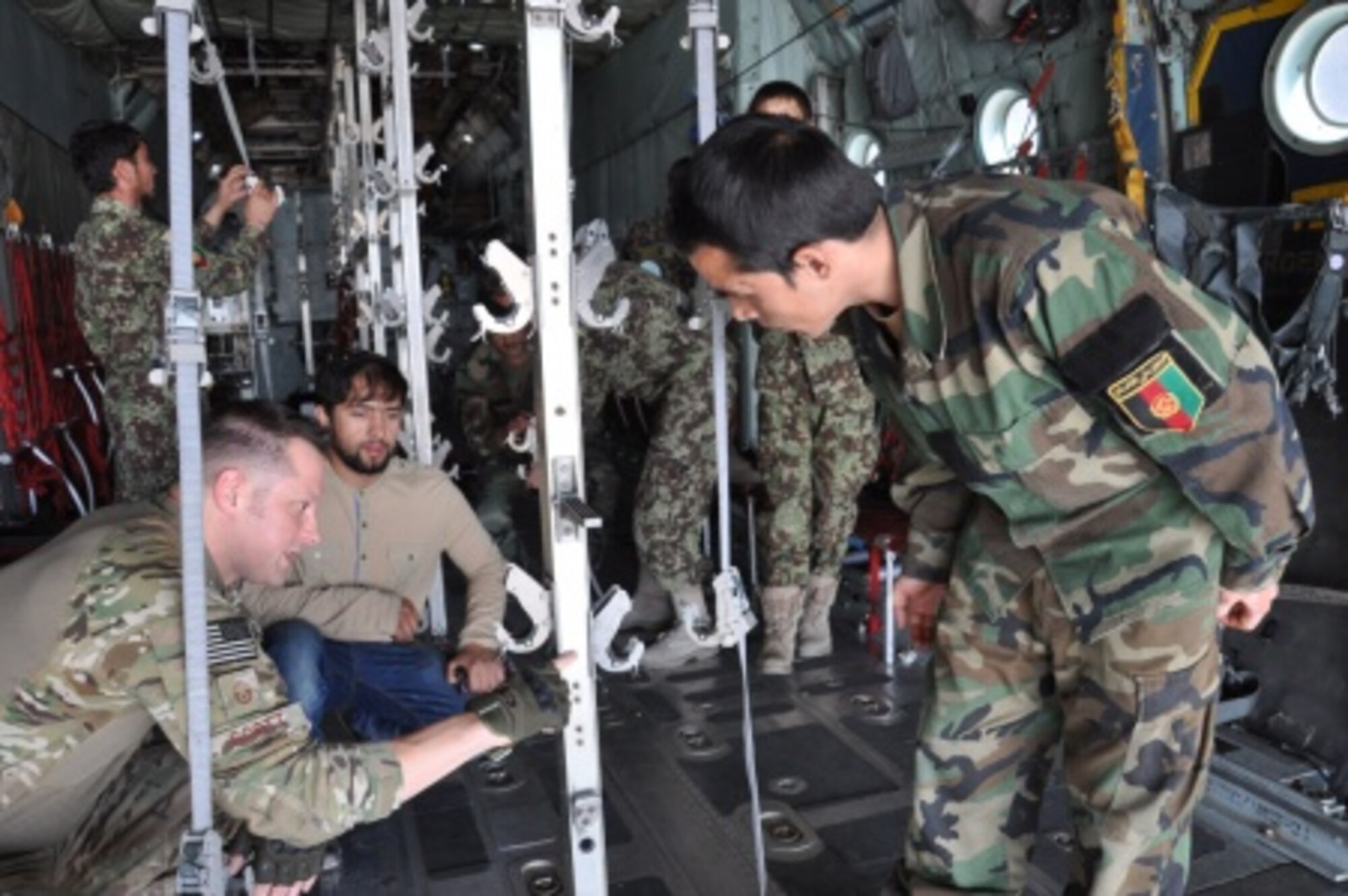 Master Sgt. Matthew Scott (left) points out to an Afghan National Army flight medic the importance of measurement and balance in the metal stanchions in the back of a C-130H Hercules at Hamid Karzai International Airport, Afghanistan, July 9, 2015. Scott is an aeromedical evacuation technician and emergency room manager at Eglin Air Force Base, Fla., who is currently the senior enlisted adviser at the nearby NATO clinic in Kabul. (U.S. Air Force photo/Capt. Eydie Sakura)
