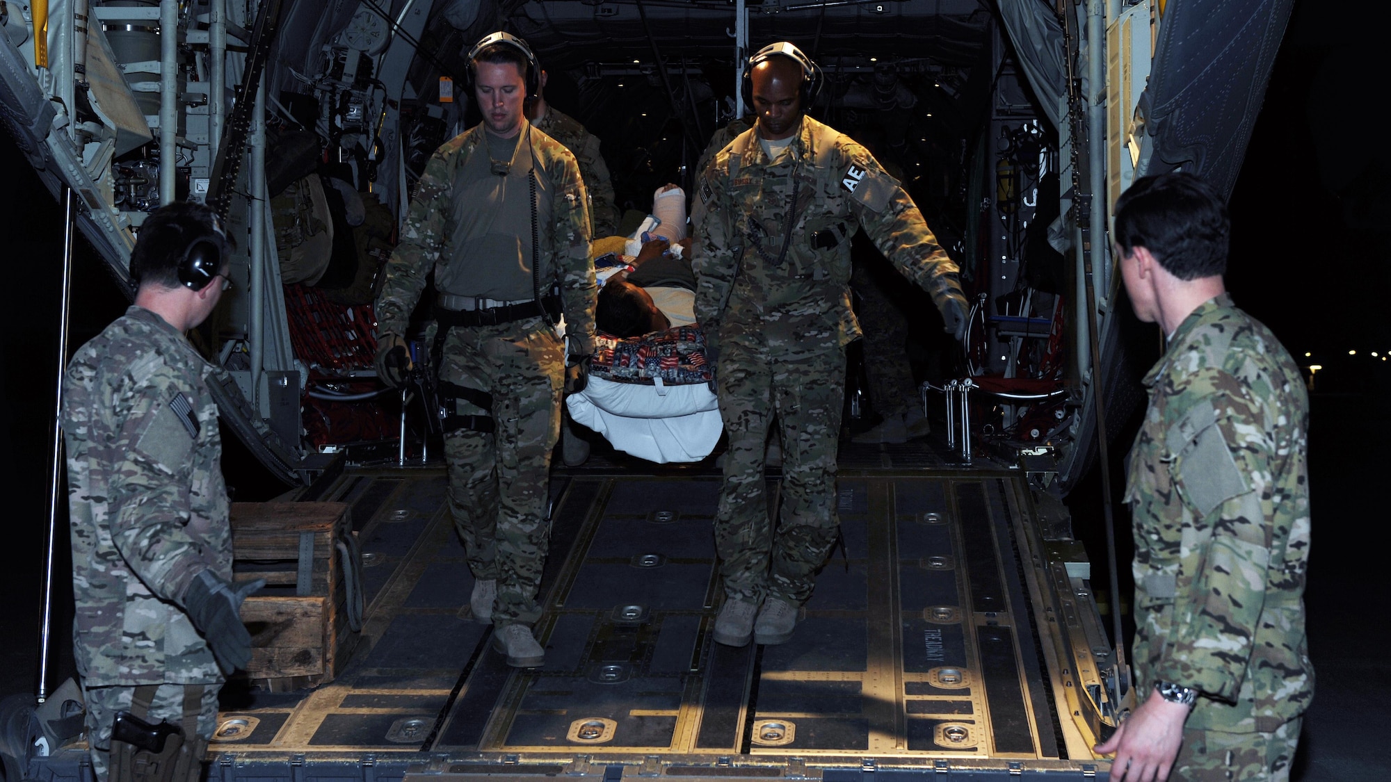 U.S. Air Force Tech. Sgt. Alexander Finn and Tech. Sgt. Johnny Busby, 455th Expeditionary Aeromedical Evacuation Squadron technicians, transport a patient from a C-130 Hercules to an ambulance in Southwest Asia, April 19, 2015. (U.S. Air Force photo by Staff Sgt. Whitney Amstutz)