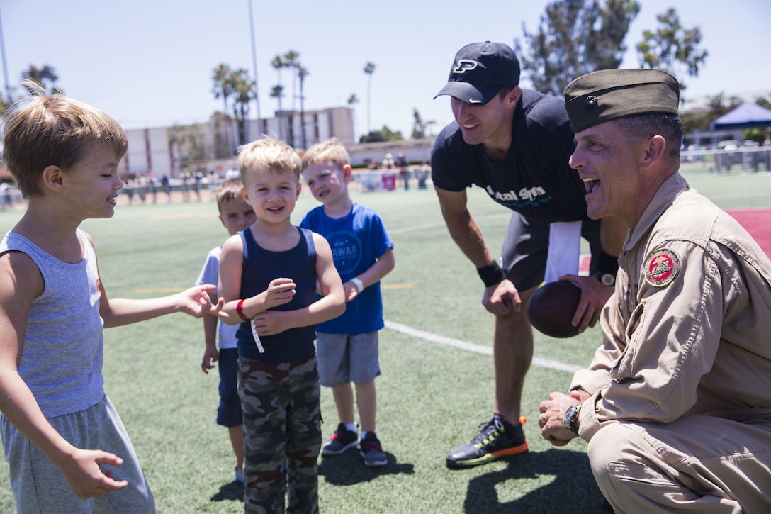 Maj. Gen. Michael Rocco, commanding general of 3rd Marine Aircraft Wing, talks with Drew Brees, starting quarterback for the New Orleans Saints, and his sons during the National Football League Star Experience at  Marine Corps Air Station Miramar, California, July 14. NFL players who train with Todd Durkin, a professional performance-enhancement coach and personal trainer, practiced with the Miramar Falcons football team and interacted with service members and families. (U.S. Marine Corps photo by Cpl. Alissa P. Schuning/Released)