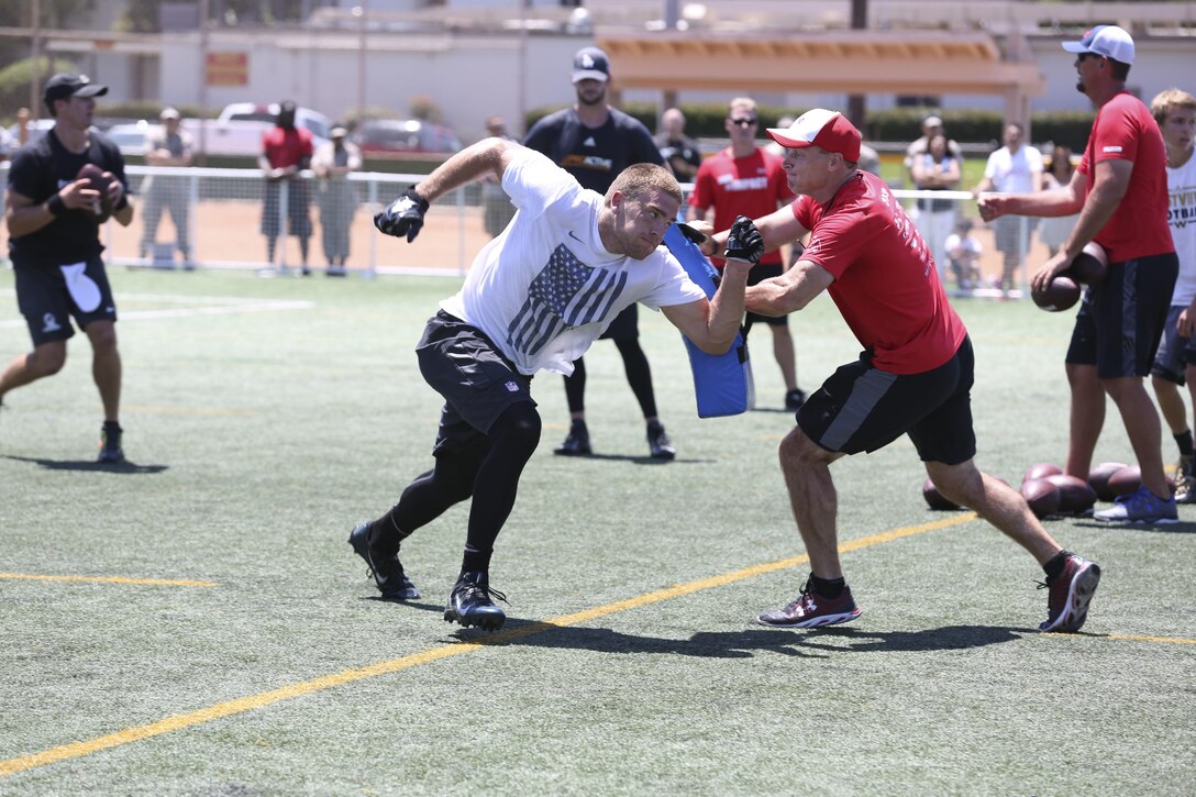 Zach Ertz, a tight end for the Philadelphia Eagles, dodges Todd Durkin, a professional performance-enhancement coach and personal trainer, during the National Football League Star Experience at Marine Corps Air Station Miramar, California, July 14. NFL players practiced with the Miramar Falcons football team and interacted with service members and families. (U.S. Marine Corps photo by Cpl. Alissa P. Schuning/Released)