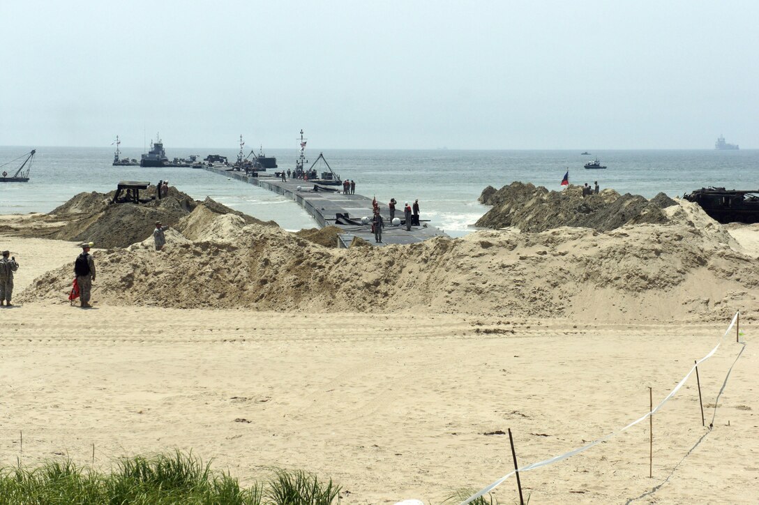ANMYEON BEACH, Republic of Korea (June 29, 2015) -- 331st Transportation Company (Modular Causeway System) inserts a temporary 560 meter (1,840 foot) Trident Pier into Anmyeon Beach on the west coast of the Republic of Korea during exercise Combined Joint Logistics Over the Shore (LOTS) 2015. LOTS are military activities that include offshore loading and unloading of ships when fixed port facilities are unavailable or denied due to enemy activities. (U.S. Navy Photo by LT Russell Wolfkiel/Released) 