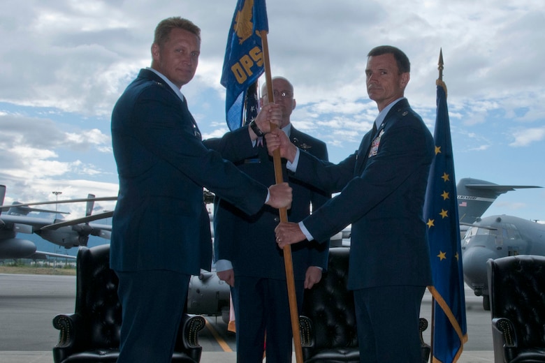 JOINT BASE ELMENDORF-RICHARDSON, Alaska --  Lt. Col. Tom Bolin accepts the flag of the 176th Operations Group, indicating his new role as commander during a ceremony here July 15, 2015. U.S. National Guard photo by Tech. Sgt N. Alicia Halla/ Released.