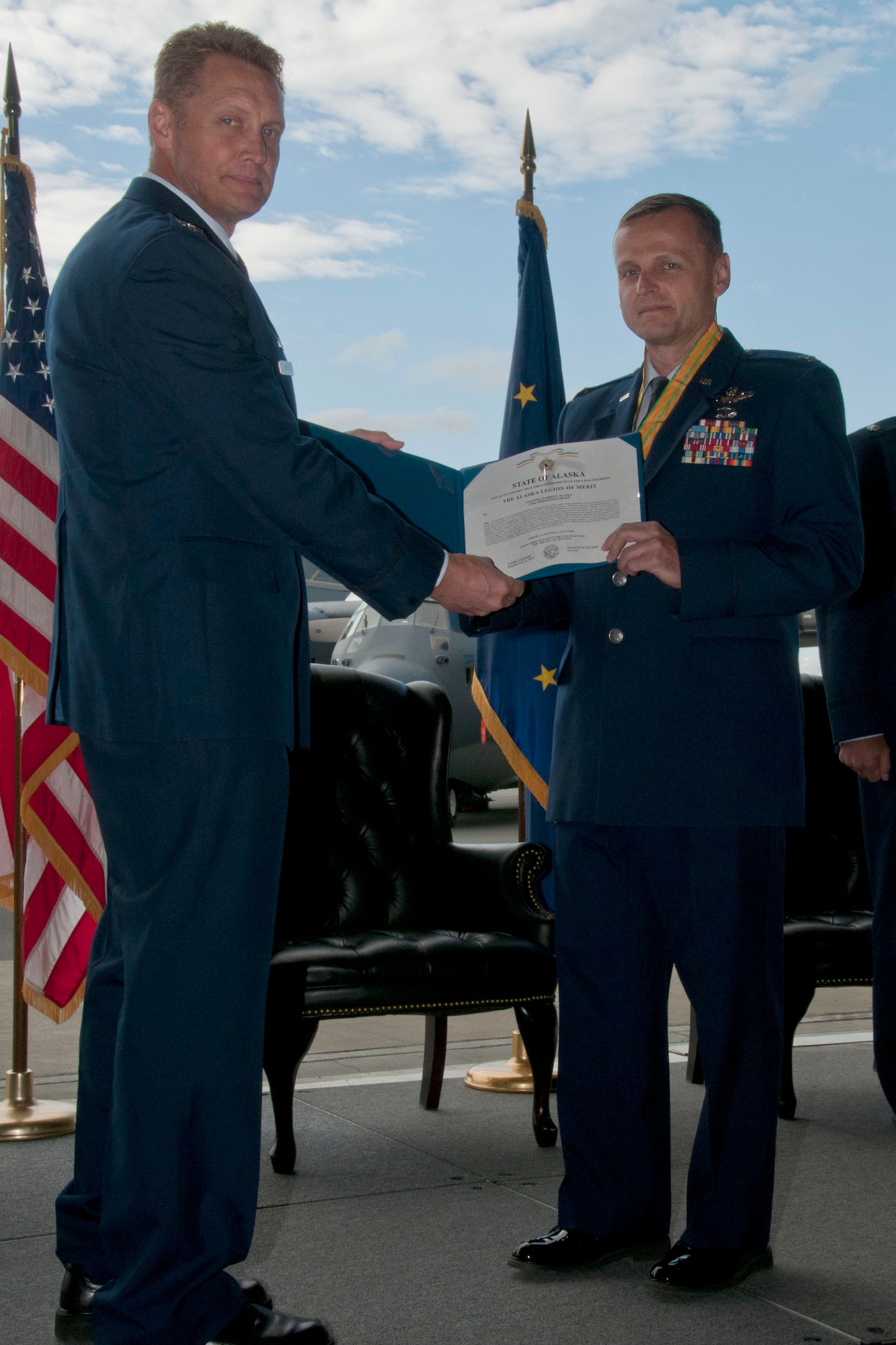 JOINT BASE ELMENDORF-RICHARDSON, Alaska -- Col. Darrin Slaten accepts the Alaska Legion of Merit as he relinquishes command of the 176th Operations Group here July 15, 2015. Members of the 176th Operations Group welcomed Lt. Col. Tom Bolin as their new commander during the ceremony. U.S. National Guard photo by Tech. Sgt N. Alicia Halla/ Released.
