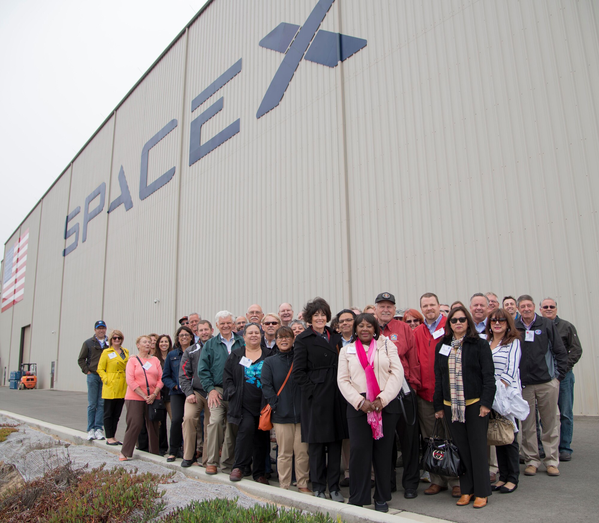 Travis’ civic leaders and honorary commanders stand in front of the SpaceX facility for a group photo during a fly-away civic leader tour to Vandenberg Air Force Base July 14, 2015. SpaceX is an aerospace manufacturer and space transport service company developing reusable rocket launching systems and supports the Falcon family of commercial space launch vehicles. (U.S. Air Force photo/Senior Airman Nicole Leidholm)