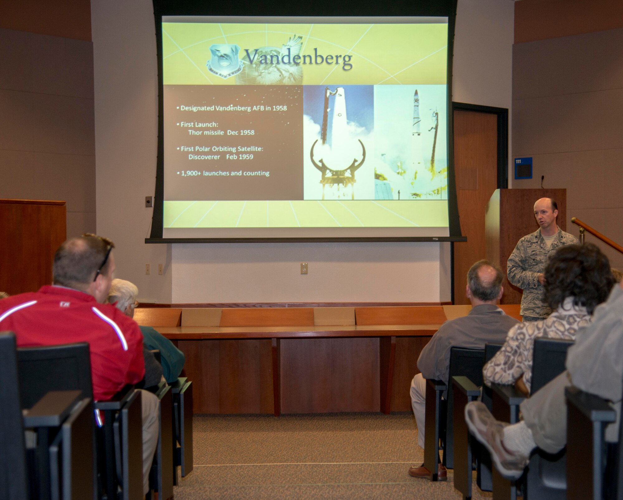 Lt. Col. Shane Clark, 30th Space Wing vice commander, gives the wings mission brief to Travis civic leaders and honorary commanders during a fly-away civic leader tour to Vandenberg Air Force Base July 14, 2015. The purpose of fly-away civic leader tours is to give community leaders an opportunity to better understand the home unit and other Air Force installations' missions. (U.S. Air Force photo/Senior Airman Nicole Leidholm)