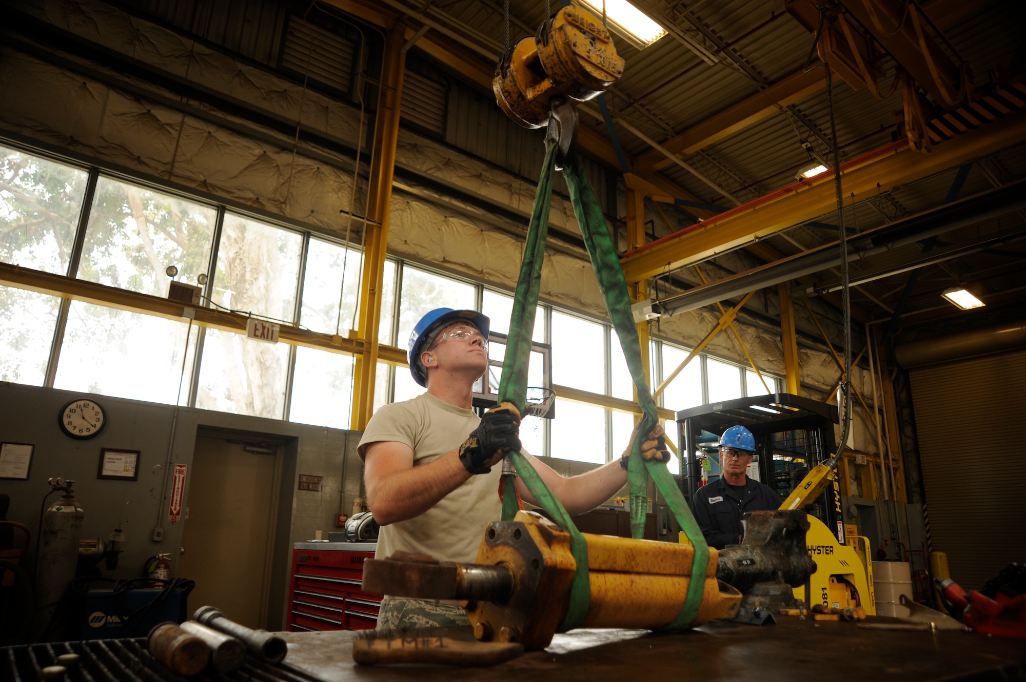 Airman 1st Class Wesley Jones, 30th Logistics Readiness Squadron vehicle mechanic, guides a fire dozer blade actuating cylinder while Darryl Dalcerri, 30th LRS vehicle mechanic, lowers the cylinder for repair, July 14, 2015, Vandenberg Air Force Base, Calif. The vehicle maintenance crew is responsible for ensuring the base’s vehicle fleet is properly maintained, safe for operational use – and mission ready at all times. (U.S. Air Force photo by Airman 1st Class Robert J. Volio/Released)