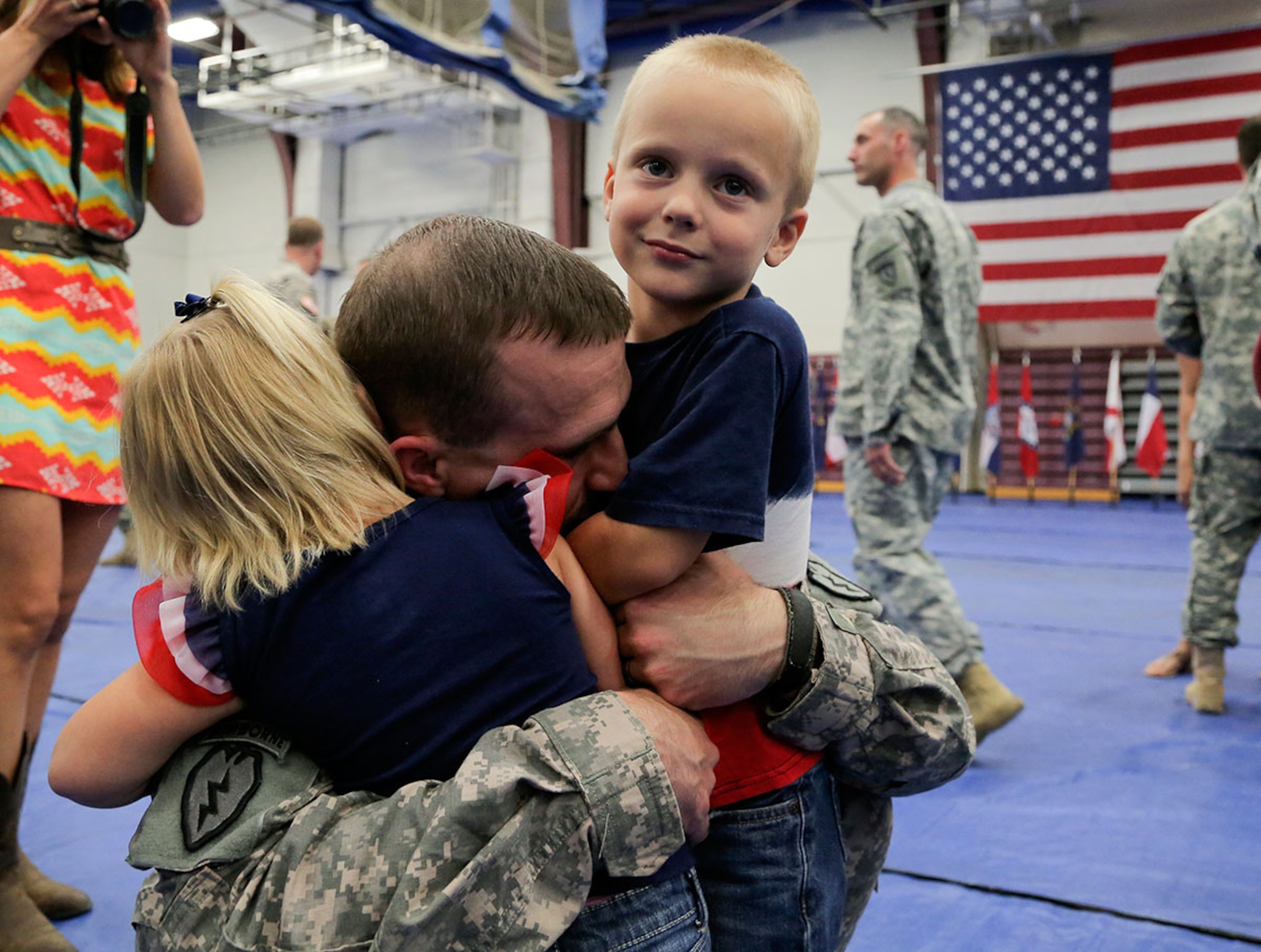 U.S. Army Capt. Daniel Lasley, assigned to Headquarters and Headquarters Company, 1st Squadron (Airborne), 40th Cavalry Regiment, hugs his children during a redeployment ceremony on Joint Base Elmendorf-Richardson, Alaska, July 10, 2015. Lasley and the contingent of paratroopers returned home from a 10 month deployment in support of peacekeeping operations in Kosovo. (U.S. Air Force photo/Alejandro Pena) 