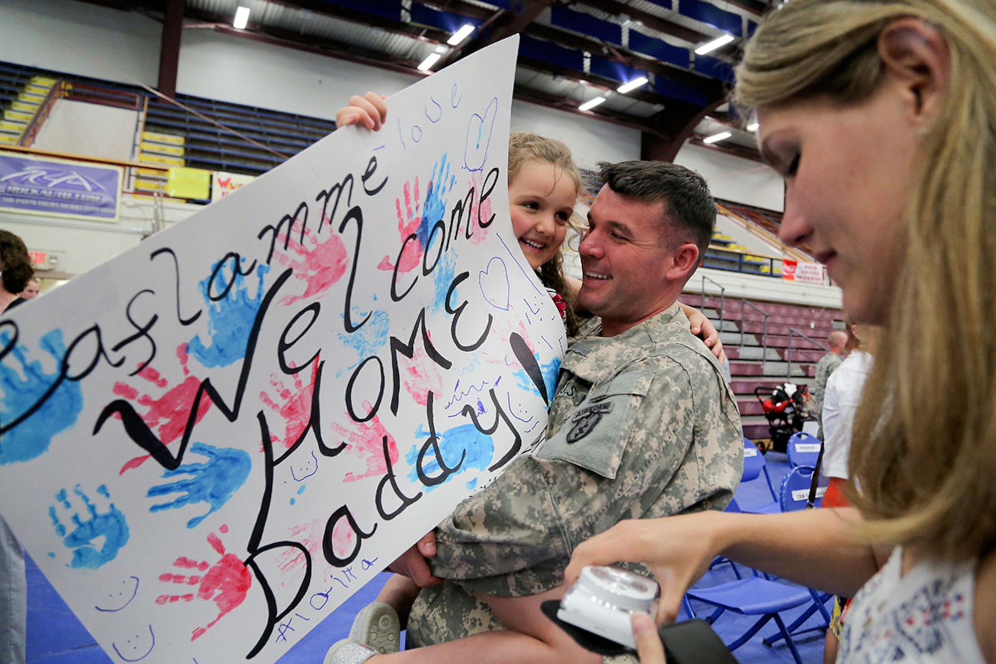 U.S. Army Staff Sgt. James Laflamme, assigned to Headquarters and Headquarters Company, 1st Squadron (Airborne), 40th Cavalry Regiment, is reunited with his family during a redeployment ceremony on Joint Base Elmendorf-Richardson, Alaska, July 10, 2015. Laflamme and the contingent of paratroopers returned home from a 10 month deployment in support of peacekeeping operations in Kosovo. (U.S. Air Force photo/Alejandro Pena) 