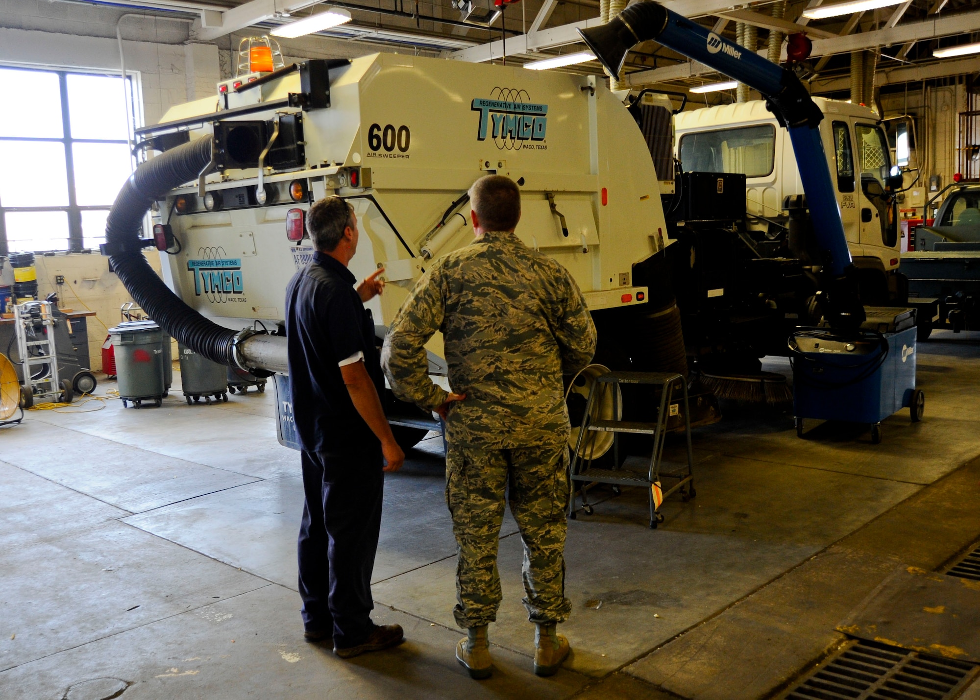 C.J. Slifko, 22nd Logistics Readiness Squadron vehicle management flight allied trades mechanic, shows Col. Albert Miller, 22nd Air Refueling Wing commander, a street-sweeper truck that was recently refurbished through in-house metal fabrication, July 15, 2015, at McConnell Air Force Base, Kan. Slifko identified the ability to replace the almost the entire back assembly with pieces fabricated in-house as opposed to ordering replacement pieces of the manufacturers, saving more than $60,000 in the process. (U.S. Air Force photo by Senior Airman Victor J. Caputo)