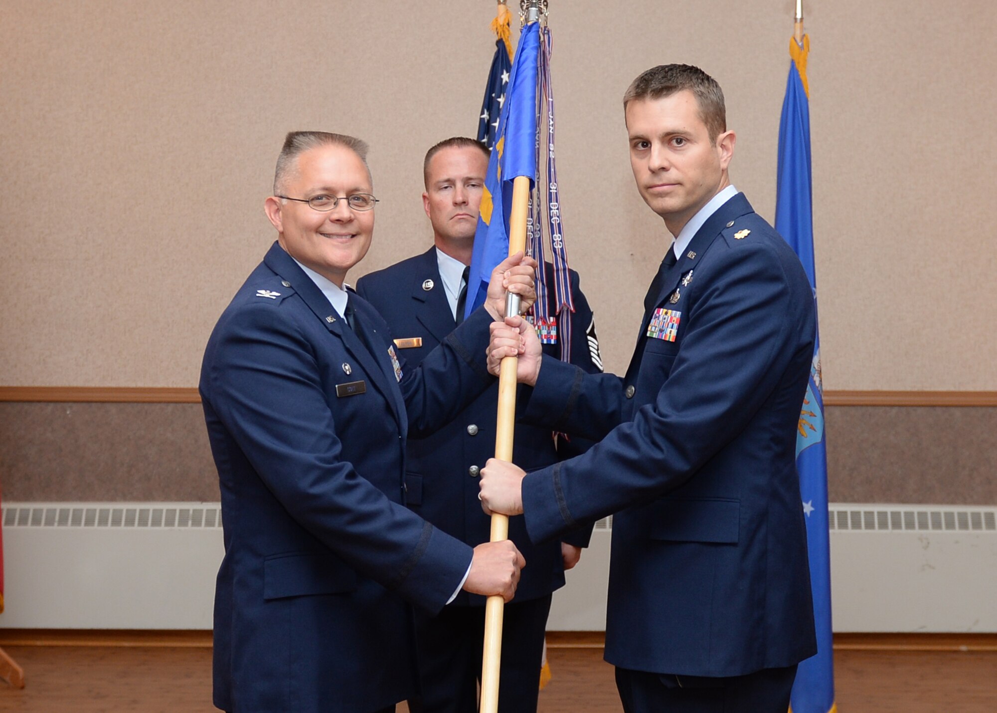 U.S. Air Force Col. Richard Cole, the 354th Mission Support Group commander, passes the 354th Communications Squadron (CS) guidon to Maj. Aaron Lake, the new 354th CS commander, July 16, 2015, at Eielson Air Force Base, Alaska. Lake was previously the deputy commander of the 86th Communications Squadron at Ramstein Air Base, Germany. (U.S. Air Force photo by Staff Sgt. Shawn Nickel/Released)