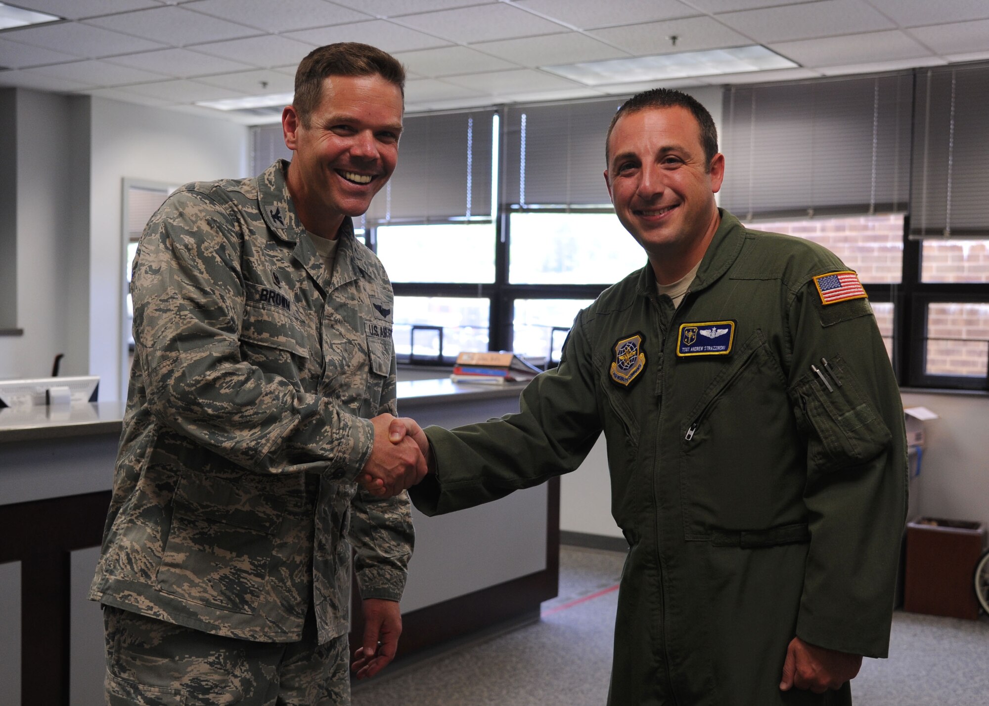 Col. Charles Brown, 19th Airlift Wing commander, congratulates Tech. Sgt. Andrew Strazzinski, a 19th Operations Group awards and decorations manager, as Combat Airlifter of the Week July 13, 2015 at Little Rock Air Force Base, Ark. Before Strazzinski moved the 41st Airlift Squadron to become a C-130J loadmaster instructor, he single-handedly processed all awards and decorations for the operations group from June 2014 to July 2015. (U.S. Air Force photo by Airman 1st Class Mercedes Muro) 