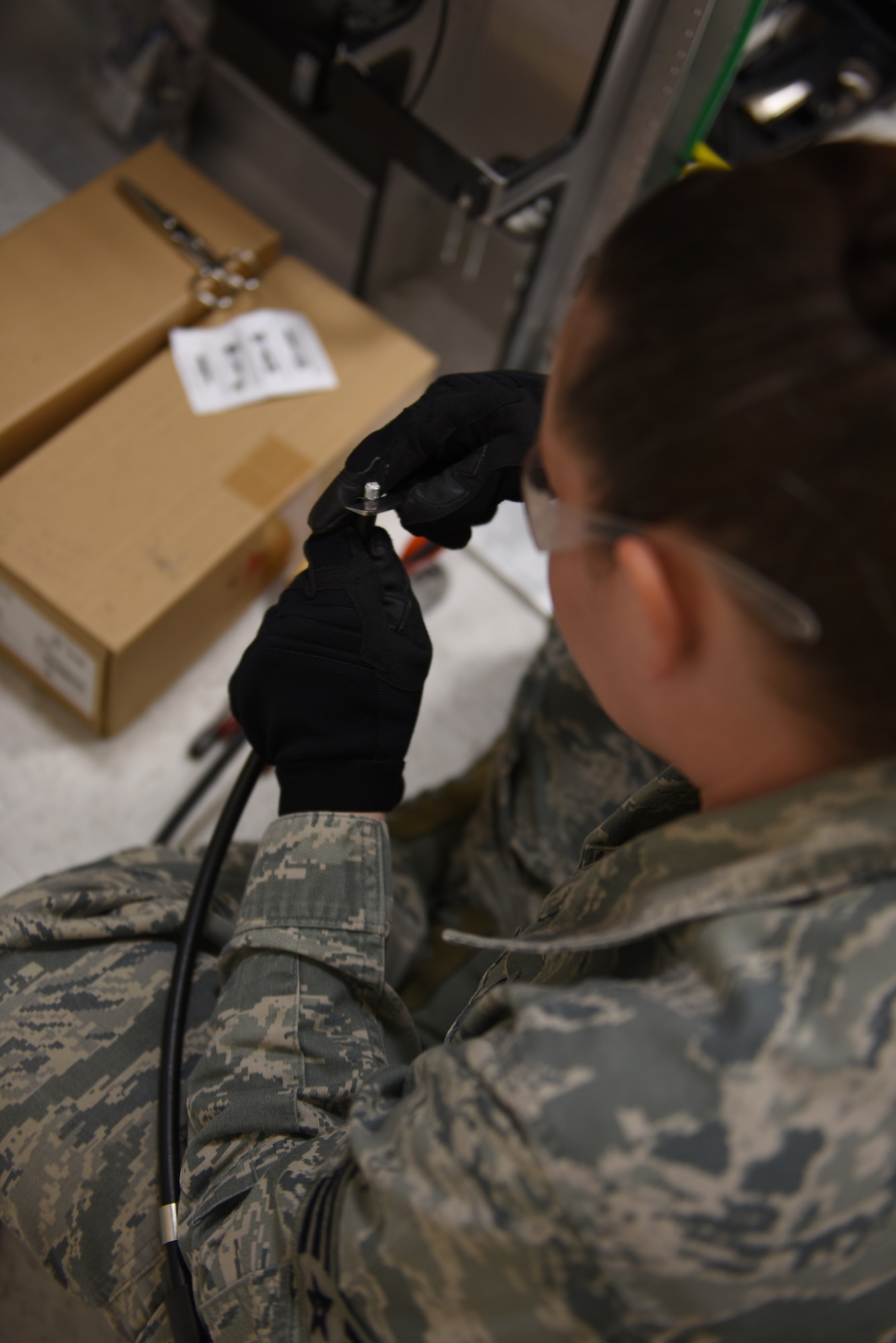 Senior Airman Holly Miller, airfield systems technician, 211th Engineering Installation Squadron, works on a cable in one of the communication rooms of the 176th Wing, Joint Base Elmendorf-Richardson, Anchorage, Alaska. Miller is a part of a seven-person team working to complete radio-antenna grounding projects as part of Exercise Frosty Spear, JBER. (U.S. Air National Guard photo by Staff Sgt. Claire Behney/Released)