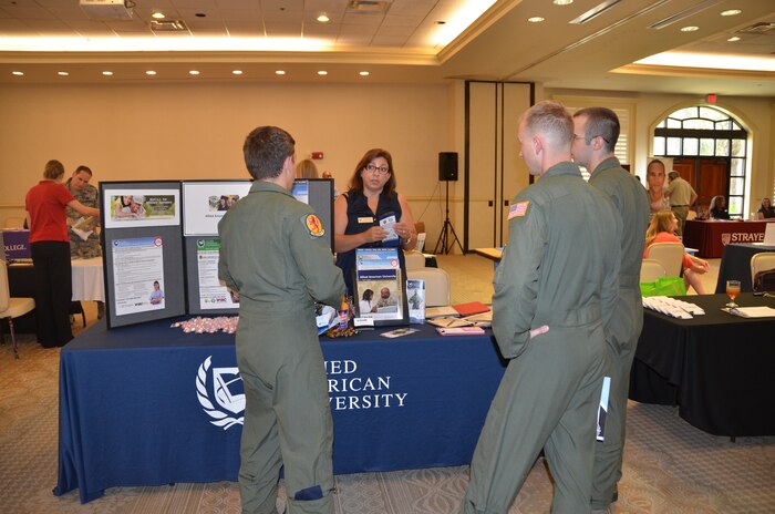 A group of Airmen speak with Penny Davila, the military Education coordinator for Allied American University July 16, 2015 during an education fair held at the club on Joint Base Charleston, S.C. The University of South Carolina, Kaplan University, Embry Riddle, Charleston Southern University and Full Sail University were five of 40 schools that were on hand to speak with members of the JB Charleston community about continued education. The VA was also on hand to answer any Montgomery GI Bill or Post 9-11 questions. (U.S. Air Force photo / Trisha Gallaway)