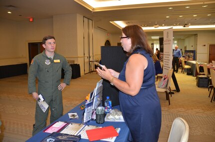 Senior Airman Tyler Pruitt, 16th Airlift Squadron loadmaster speaks with Penny Davila, the military Education coordinator for Allied American University July 16, 2015 during an education fair held at the club on Joint Base Charleston, S.C. The University of South Carolina, Kaplan University, Embry Riddle, Charleston Southern University and Full Sail University were five of 40 schools that were on hand to speak with members of the JB Charleston community about continued education. The VA was also on hand to answer any Montgomery GI Bill or Post 9-11 questions. (U.S. Air Force photo / Trisha Gallaway)
