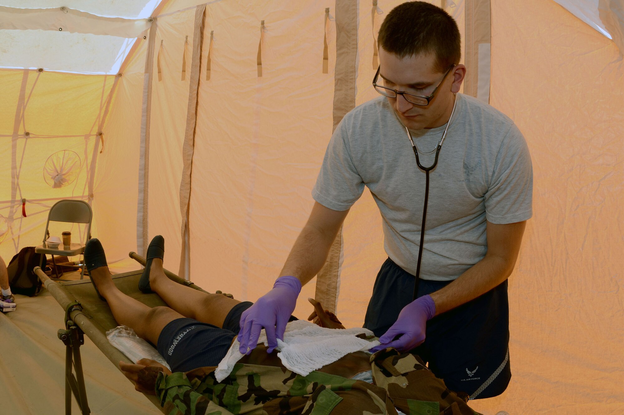 U.S. Air Force Senior Airman Zechariah Palmisano, an aerospace medic with the 169th Medical Group, applies gauze to a simulated patient during a mass casualty exercise at McEntire Joint National Guard Base, S.C., June 18, 2015. McEntire Joint National Guard Base simulated a vehicle collision on base to offer personnel real-world training should an event ever occur in a real world capacity. (South Carolina Air National Guard photo by Amn Megan Floyd/Released)
