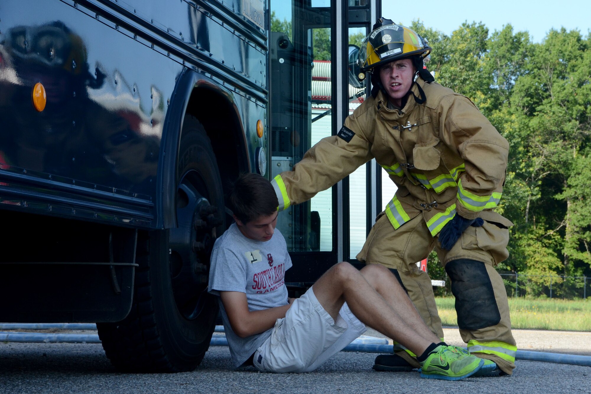 U.S. Air Force Airman 1st Class Kristopher Eiser, a firefighter with the 169th Civil Engineer Squadron, assists Christopher Boatwright, the assistant scout master for Troop 95, who is suffering from a simulated injury during a mass casualty exercise at McEntire Joint National Guard Base, S.C., June 18, 2015. McEntire Joint National Guard Base simulated a vehicle collision on base to offer personnel real-world training should an event ever occur in a real world capacity. (South Carolina Air National Guard photo by Amn Megan Floyd/Released)