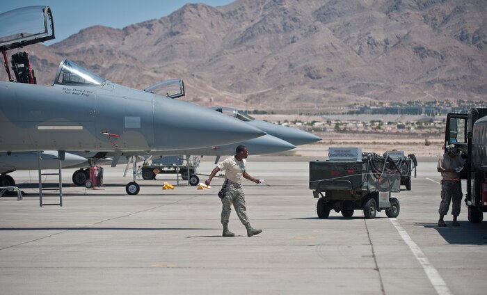 Senior Airman Quenton Richardson, 159th Maintenance Squadron crew chief, Louisiana Air National Guard, works with a petroleum, oils and lubricants Airman to refuel an F-15 Eagle during Red Flag 15-3 at Nellis Air Force Base, Nev., July 14, 2015. Red Flag provides realistic combat training in a contested, degraded and operationally-limited environment, which provides aircrews with real-time war scenarios and helps ground crews test and improve their operational readiness. (U.S. Air Force photo by Staff Sgt. Siuta B. Ika)