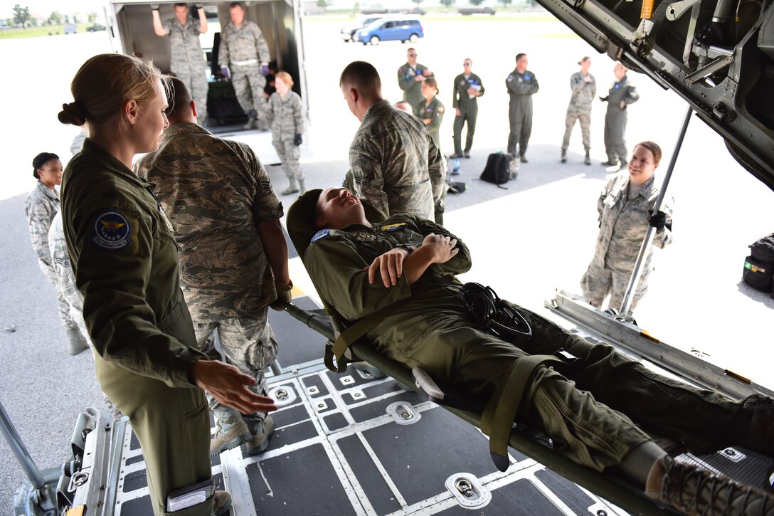 The patient is carried carefully off the plane.  Senior Airman Ron Eckerman, 932nd Aeromedical Evacuation Squadron, plays the part of a "patient" during a recent scenario to increase cooperation between AES and the 932nd Aeromedical Staging Squadron who helped to off load him from the visiting C-130.  (U.S. Air Force photo/Tech. Sgt. Christopher Parr)