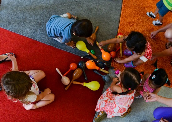 Children share musical instruments during JAM Summer Camp, July 14, 2015, at Aviano Air Base, Italy. The class included different exercises to help broaden children’s attention spans. (U.S. Air Force photo by Senior Airman Austin Harvill/Released)